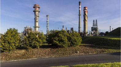 We see a CO2 storage factory behind some trees.