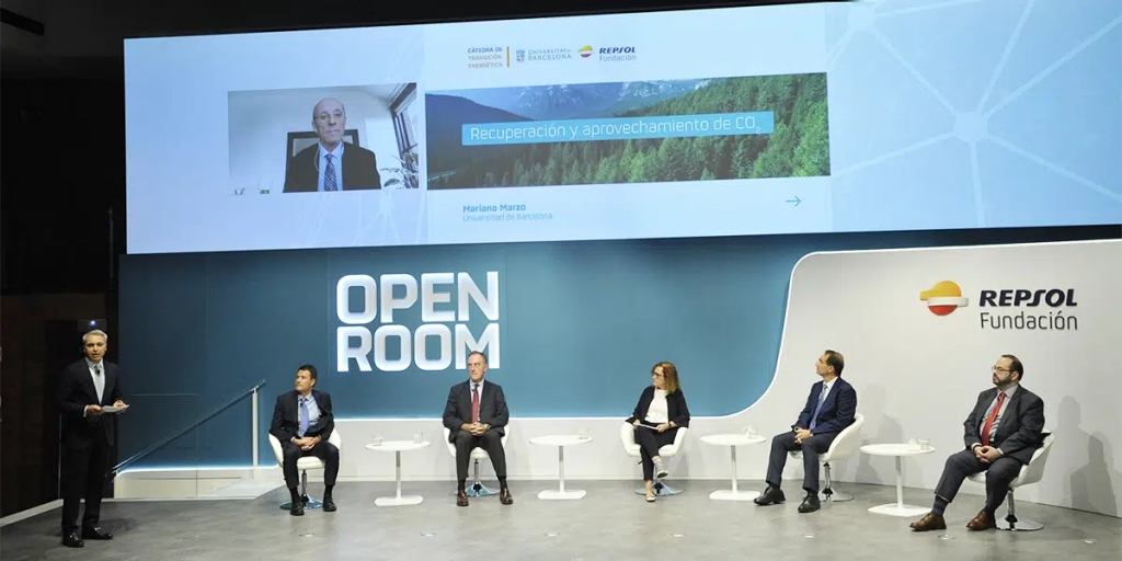 Conferencia Open Room de Repsol en la que podemos ver a Varios ponentes sentados en el escenario con el logotipo de Open Room al fondo