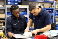 Two Hispaled workers assemble an electronic component