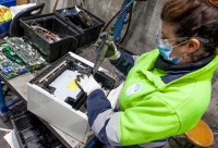 Un operario desmonta un ordenador en una planta de reciclaje