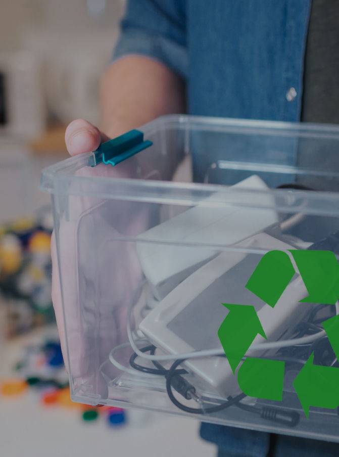 Un hombre sostiene una caja transparente con diferente aparatos electrónicos para reciclar